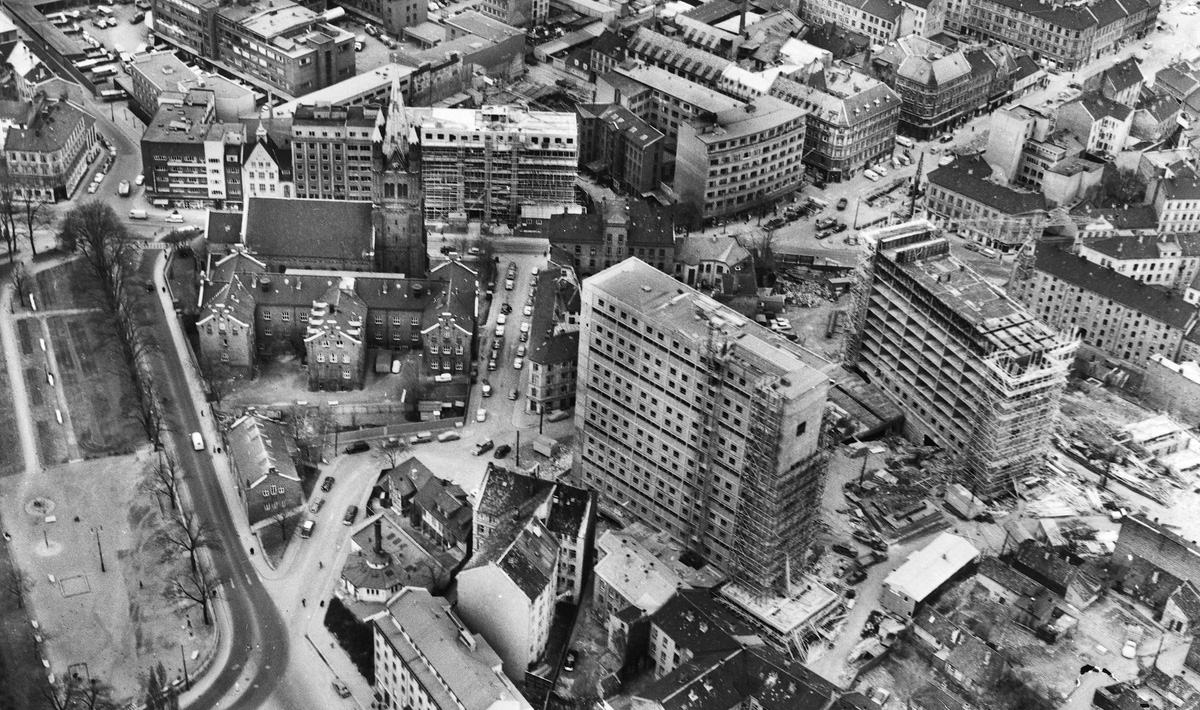 RYDDESJAU: Slik begynte området å avtegne seg fra lufta i 1962. Husmorskolen/Fafo-bygget til venstre, foran kirka. Både Åkebergveien og høyblokkene er i støpeskjeen og flere bygg vil rives – pluss ankomsten til et politihus i venstre billedkant, men området er her langt på vei slik det framstår i dag.