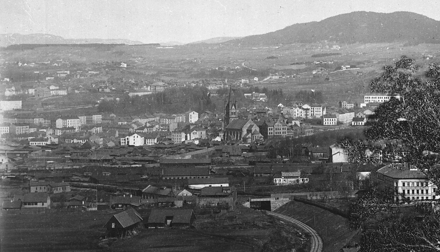 SETT FRA EKEBERGÅSEN rundt 1880-årene framstår Grønland fremdeles som et område preget av lav trehusbebyggelse og landlige omgivelser målt mot «murbyen» i det gamle Christiania. Langs ferdselsveien mot byens østlige inngangsport, Vaterland, og ved foten av bakken opp til det høyereliggende fattigstrøket Enerhaugen, hadde Grønland vokst fram til å bli en berykted forstad.